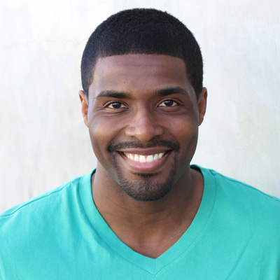An elderly couple smiling and embracing, with the man to the left and the woman to the right.